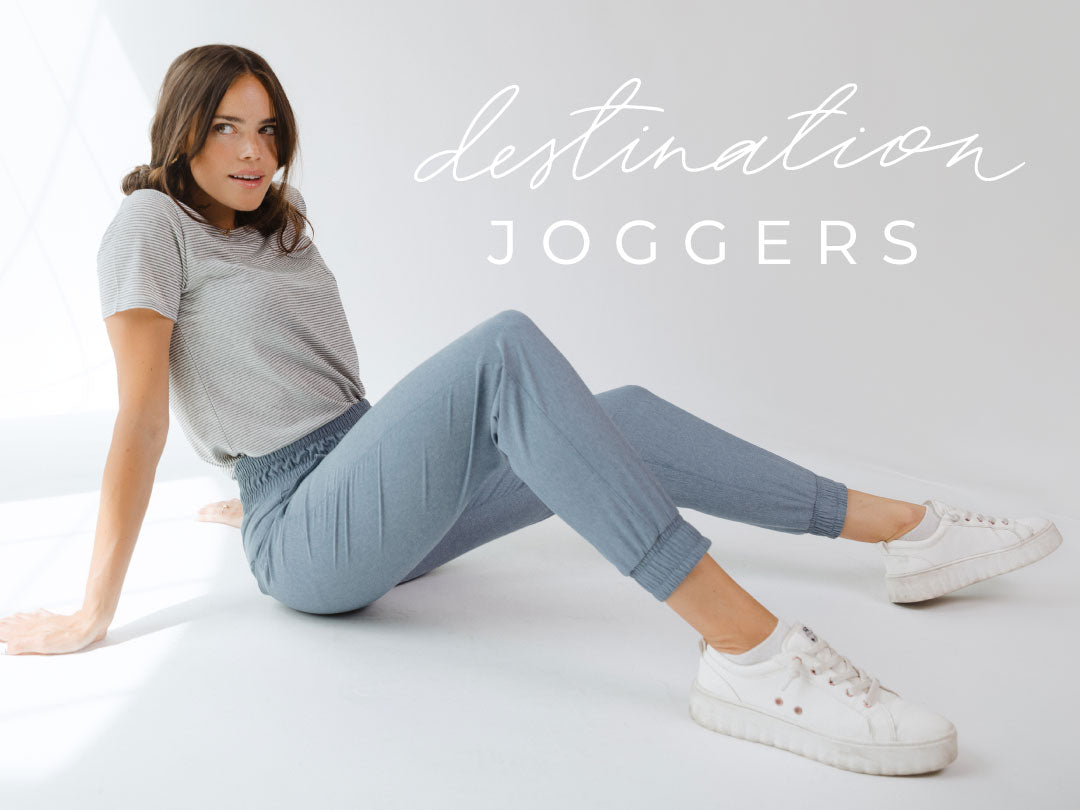 Front view of blue-gray Destination Joggers showcasing elastic cuffs and waistband on a seated model against a white background
