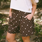 Close up of woman wearing brown polka dot shorts with hidden Minnies—the perfect women's Disney shorts. 