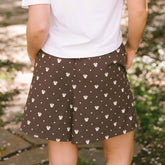 Close up back view of woman wearing brown polka dot shorts with hidden Minnies—the perfect shorts for Disneyland.