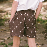 Close up back view of child wearing brown Minnie shorts for kids. 