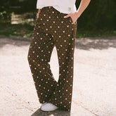 Close up of woman wearing subtle Disney pants in brown polka dot print with hidden Minnies on a blurred background.