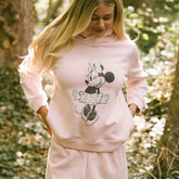 Close up of woman in a garden wearing a pink women's Disney hoodie with screen printed Minnie Mouse.