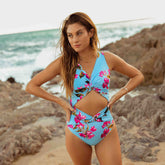 Model wearing cut out one piece women's bathing suit in sky blue with pink floral print 