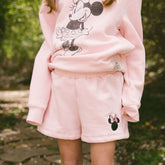 Close up of child wearing pink kids Disney shorts with embroidered Minnie Mouse detail on the shorts. 