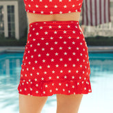 Red and white star-patterned two-piece swimsuit by a pool.