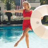 Woman standing near a pool wearing a 4th of July swimsuit in red and white stars 
