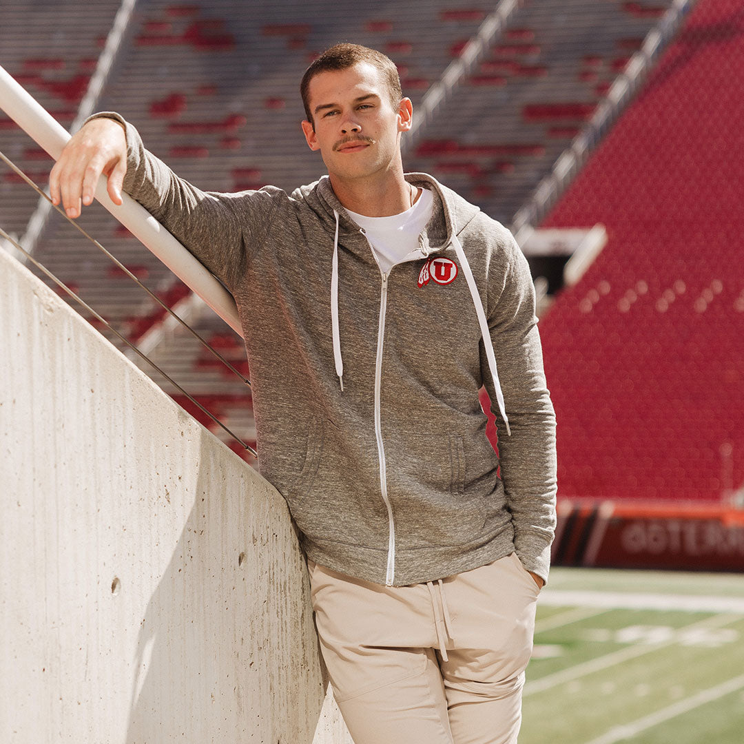 Guy standing with Utah Zip Jacket at stadium