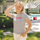 Woman wearing a 4th of July t-shirt for women in navy blue stripes with embroidered america 