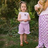 Child in a garden wearing a cute Disney outfit for kids—Disney shorts for kids and Minnie Mouse shirt for kids. 