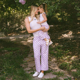 Mom and daughter standing in a garden wearing matching Disneyland outfits for families