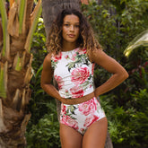 Woman wearing a floral two-piece swimsuit in a tropical setting