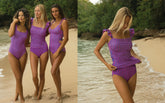 Two women in matching purple and pink striped swimsuits on a beach.