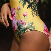 Yellow swimsuit with floral design worn by a person, with a focus on the side