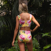 Woman wearing a floral bikini set in a tropical setting