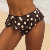 Brown bikini bottom with white polka dots on a neutral background