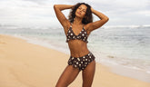 Woman in a polka dot bikini standing on a beach