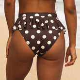 Brown bikini bottom with white polka dots on a neutral background