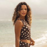 Woman wearing a polka dot swimsuit standing on a beach