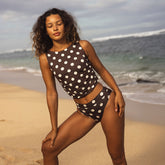 Woman in a polka dot swimsuit standing on a beach