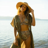 Woman in a the cutest two piece swimsuit and olive green cover-up dress by the ocean