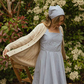 Model wearing blue bandana with cute blue seersucker dress. 