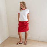 Front view of the red polka-dot City Skirt showcasing its elastic drawstring waist and knee-length fit on a model in a neutral room