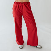 Front view of red polka dot slip-on trousers showcasing wide-leg fit on a model against a light background