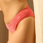 Close-up of a person wearing a pink glittery bikini bottom with a blurred background