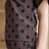 Polka dot shirt with a brand logo on a blurred background