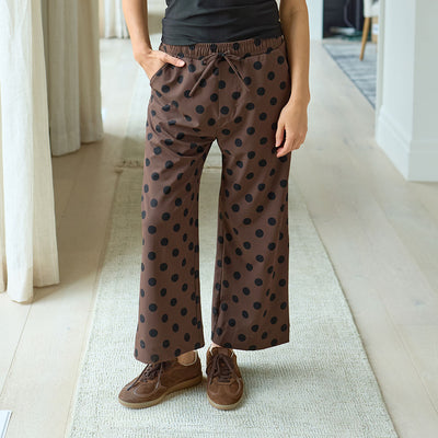Woman wearing brown polka dot women's pants indoors