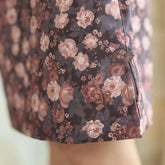 Close up details of a brown floral skirt with visible Albion logo stitched onto it with a blurred background.