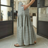 Woman wearing a long taupe maxi skirt for women in a modern living room.