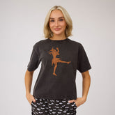 Front view of vintage black Perfect Jester Tee with orange jester graphic and loose fit on model against gray background