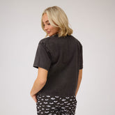 Back view of Perfect Jester Tee in vintage black showing short sleeves and cropped hem on a model against a light gray background