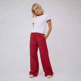 Front view of a red polka dot slip on trouser worn by a model, showing a wide-leg fit against a gray background
