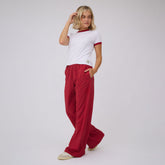 Three quarter view of red polka dot Slip On Trouser showcasing wide leg fit and side pockets with a light gray studio background