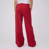 Rear view of red polka dot Slip On Trouser showcasing wide legs on a model against a light gray background