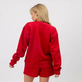 Person wearing a red sweatshirt and shorts set on a white background