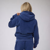 Back view of navy BYU Campus Hoodie showcasing its hood on a model against a light gray background