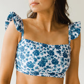 Close up of bandeau swim crop with blue flowers on white