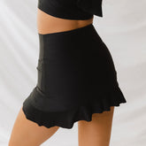 Woman wearing matte black high-waisted swim skirt by Albion Fit