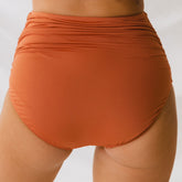 Model shown in swim bottoms rust color