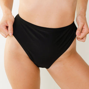 Woman wears Kelsey high cut bikini bottoms in black