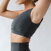 side view of woman wearing black and white crop swimsuit 