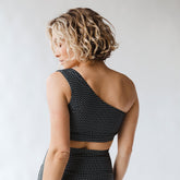 woman showing the back of black and white pattern swim top