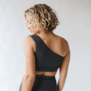 woman showing the back of black and white pattern swim top
