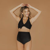 woman wearing matte black high waisted ruched swim bottoms