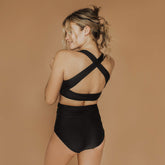 Back view of criss cross straps of matte black swim top