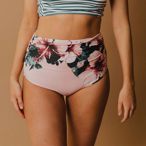 close up of woman wearing pink high waisted swim bottoms with floral design