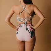 woman showing the back of pink high waisted ruched swim bottoms